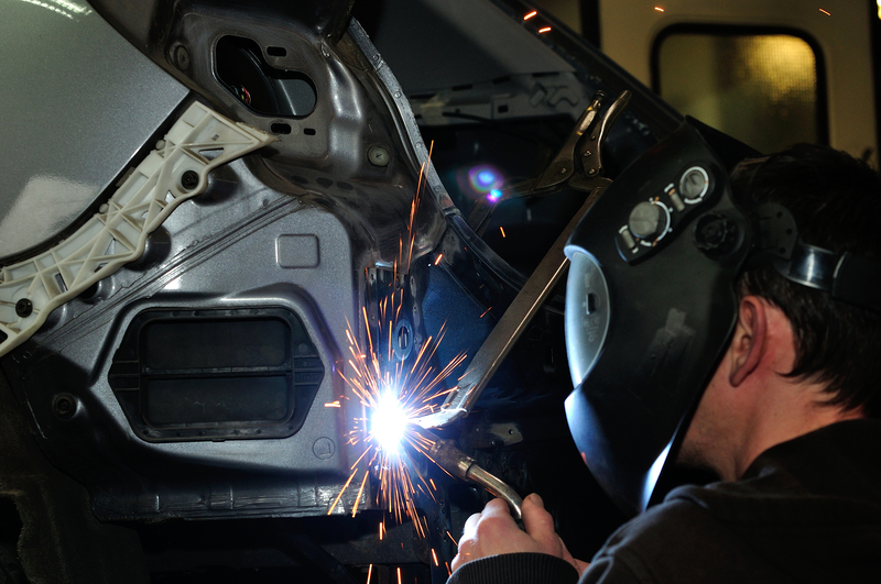 Auto body technician welding a vehicle