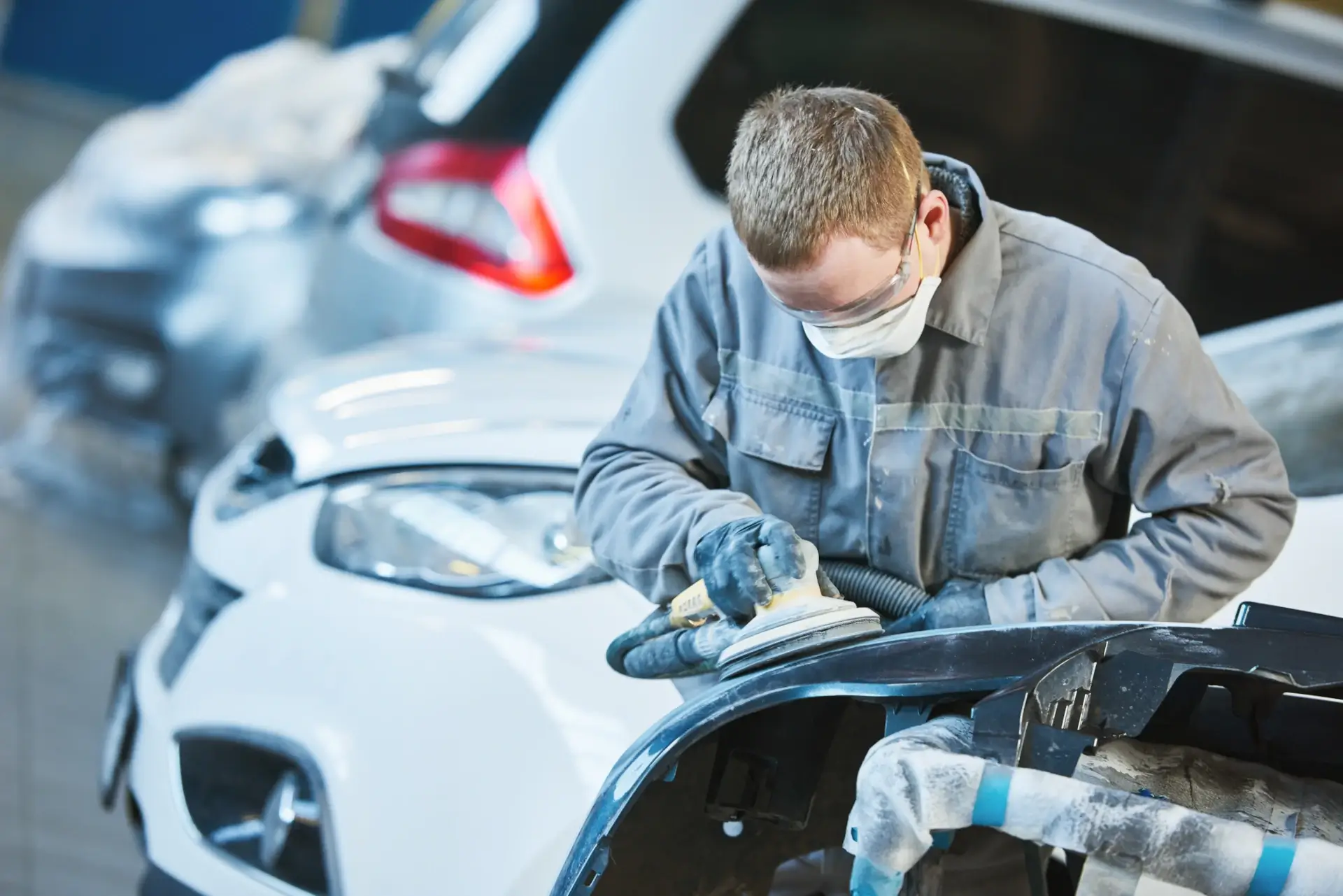 Auto body technician sanding body panel