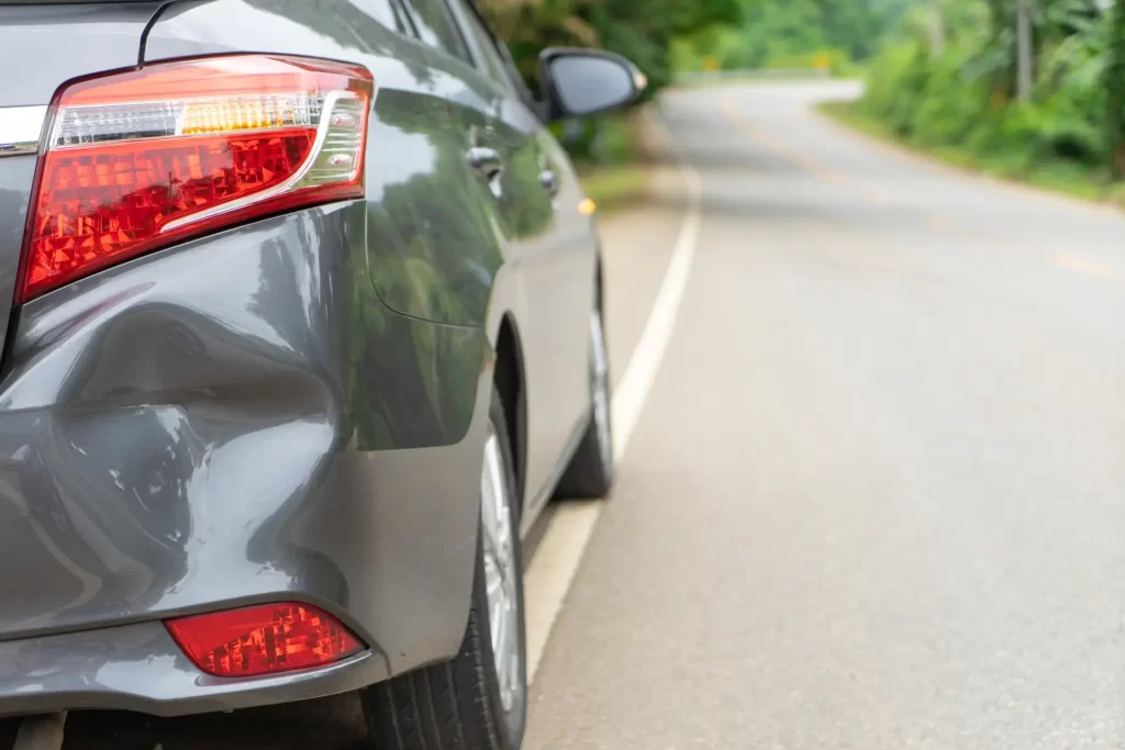 rear bumper dent on gray vehicle showing minor collision damage