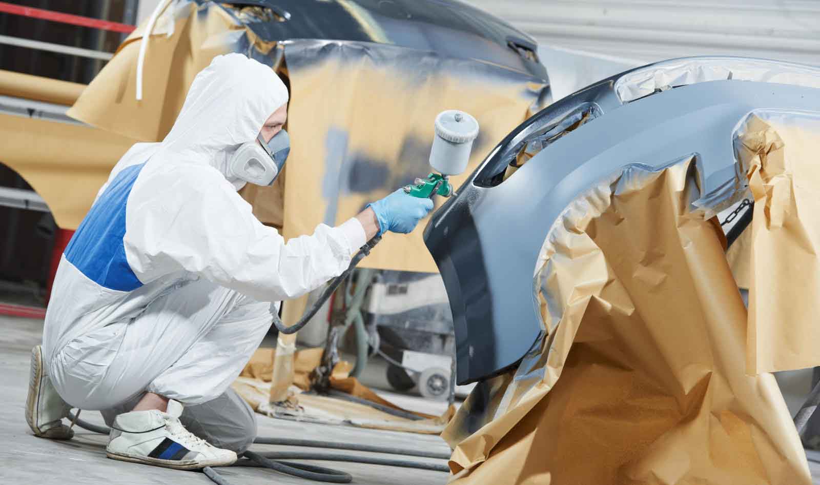 Man Painting Car in Spray Booth