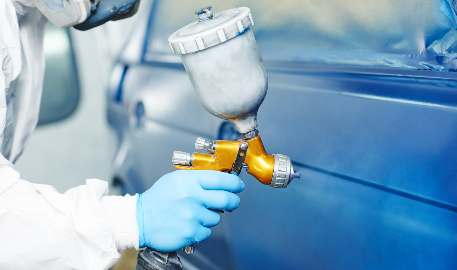 technician painting blue car